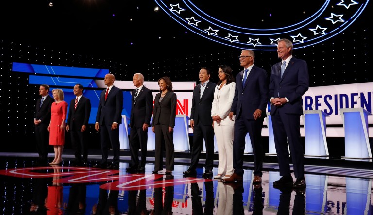 Democratic candidates stand around before a debate.