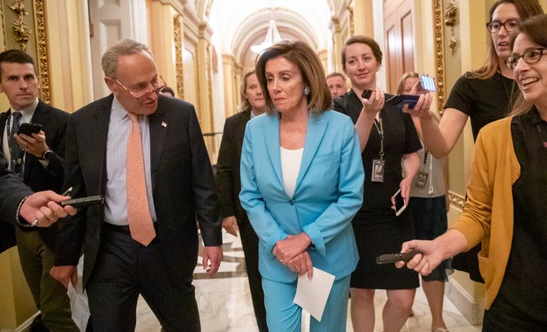 Senate Minority Leader Chuck Schumer, D-N.Y., left, joins Speaker of the House Nancy Pelosi, D-Calif., on the way to sign the budget package just passed in the Senate, at the Capitol in Washington, Thursday, Aug. 1, 2019. 