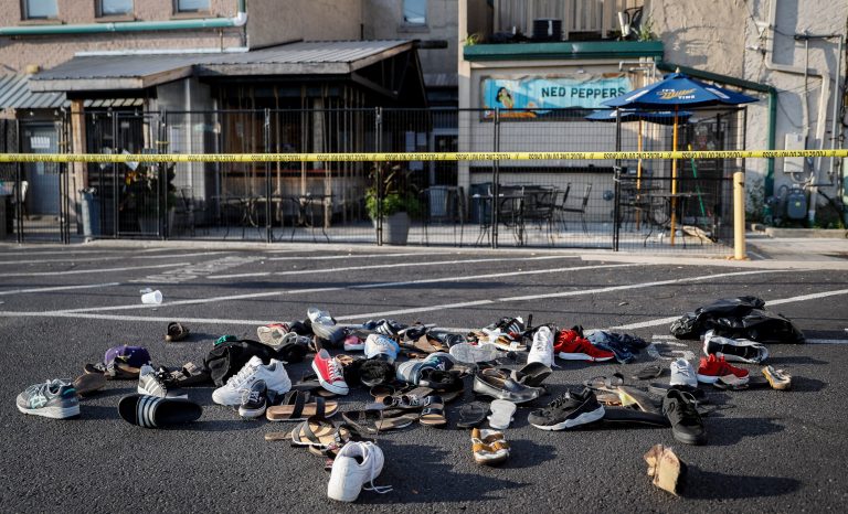 Shoes are piled outside the scene of a mass shooting including Ned Peppers bar, Sunday, Aug. 4, 2019, in Dayton, Ohio. 
