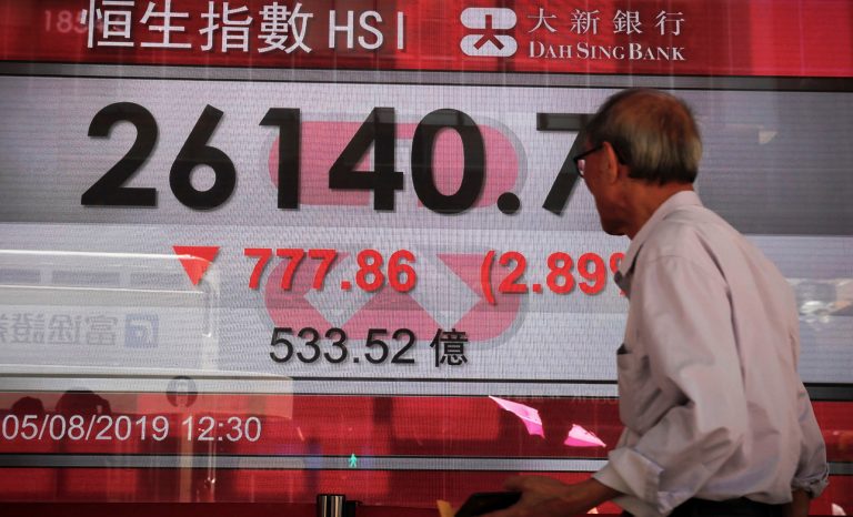 An elderly man looks at an electronic board showing Hong Kong composite index outside a bank in Hong Kong, Monday, Aug. 5, 2019. 