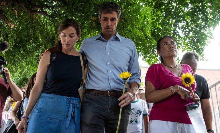 Democratic presidential candidate Beto O'Rourke walks next to his wife Amy Hoover Sanders and Rep. Veronica Escobar Sunday, Aug. 4, 2019, during a silent march holding sunflowers in honor to the victims of a mass shooting occurred in Walmart on Saturday, Aug. 3, 2019, in El Paso, Texas.