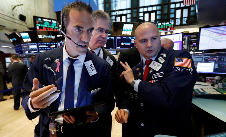 Traders Gregory Rowe, left, and Daniel Kryger, center, work with specialist Mario Picone on the floor of the New York Stock Exchange, Tuesday, Aug. 6, 2019. 