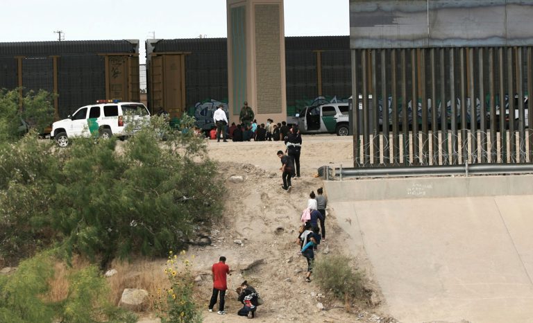 In this June 15, 2019 photo, migrants cross the Rio Bravo illegally to surrender to the American authorities on the US - Mexico border between Ciudad Juarez and El Paso. 