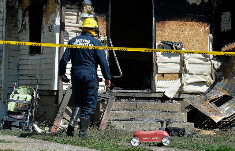 Erie Bureau of Fire Inspector Mark Polanski helps investigate a fatal fire at 1248 West 11th St. in Erie, Pa, on Sunday, Aug. 11, 2019.