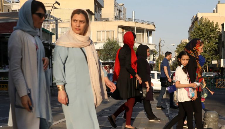Pedestrians walk on a sidewalk in eastern Tehran, Iran, Monday, Aug. 19, 2019. 