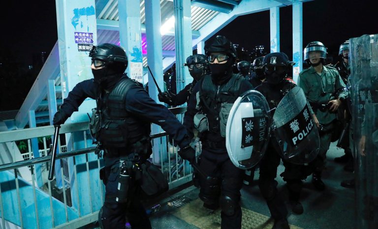 Riot police gather outside the Yuen Long MTR station during a protest in Hong Kong, Wednesday, Aug. 21, 2019.  
