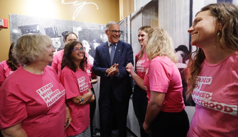 Gov. Jay Inslee talks with supporters of Planned Parenthood after speaking at a news conference addressing a change in rules on the nearly 50-year-old Title X family planning program, Thursday, Aug. 22, 2019, in Seattle. 