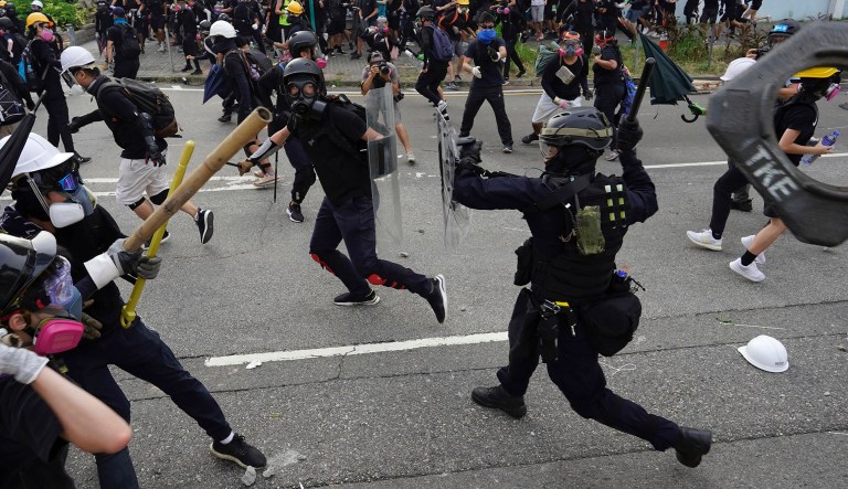 Police and demonstrators clash during a protest in Hong Kong, Saturday. The protesters were part of a larger group marching to demand the removal of smart lampposts installed in a Kowloon district over fears they could contain high-tech cameras and facial recognition software used for surveillance by Chinese authorities. 