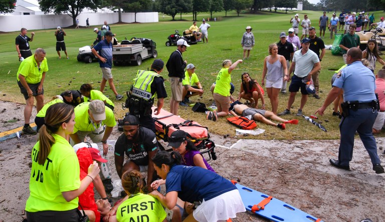 Spectators are tended to after a lightning strike on the East Lake Golf Club course left several injured during a weather delay in the third round of the Tour Championship golf tournament Saturday in Atlanta.
