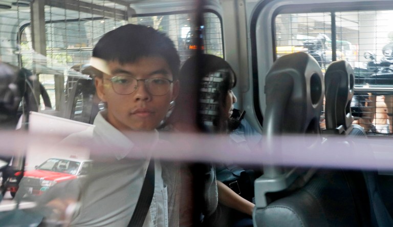 Pro-democracy activists Joshua Wong, left, and Agnes Chow, are escorted in a police van at a district court in Hong Kong. Hong Kong police arrested well-known activists Wong and Chow on Friday, and authorities denied permission for a major march in what appears to a harder line on this summer's protests. 