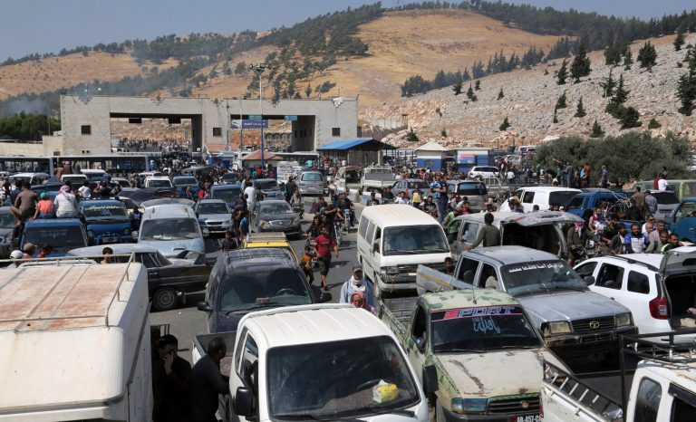 Cars and trucks line up to enter Turkey as hundreds of protesters gather during a demonstration at the Bab al-Hawa border crossing with Turkey, Syria, Friday, Aug. 30, 2019, demanding that Ankara either open the border or end attacks by the government. 