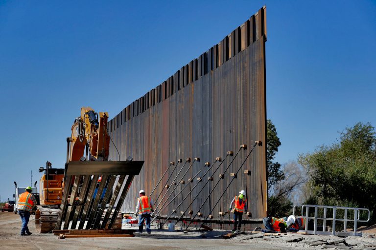 Government contractors erect a section of Pentagon-funded border wall along the Colorado River, Tuesday, Sept. 10, 2019 in Yuma, Ariz. The administration expects to construction to ramp up to one mile a day next year.
