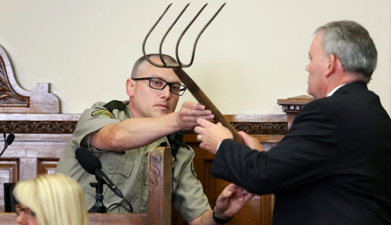 Delaware County's county attorney John Bernau, right, questions witness Delaware County Deputy Eric Holub as he hands back a corn rake during the first-degree murder trial for Todd Mullis at Dubuque County Courthouse in Dubuque, Iowa, on Tuesday, Sept. 17, 2019. 