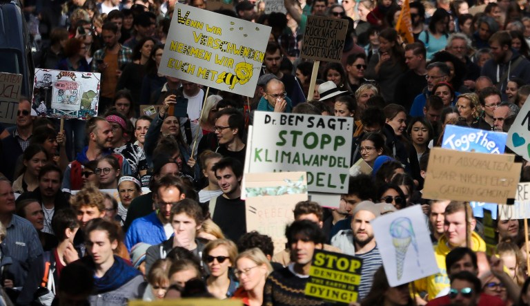 Demonstrators hold posters as they attend the 'Friday for Future' climate protest near the Brandenburg Gate in Berlin.