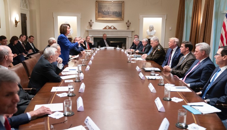 In this photo released by the White House, President Donald Trump, center right, meets with House Speaker Nancy Pelosi, standing left, Congressional leadership and others, Wednesday, Oct. 16, 2019, in the Cabinet Room of the White House in Washington. 