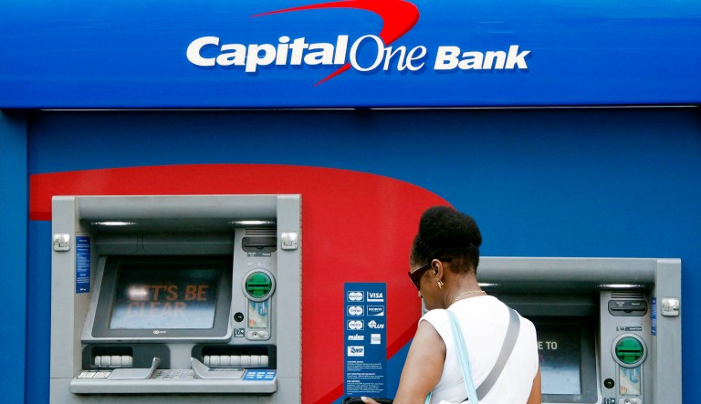 A woman uses a Capital One bank ATM.