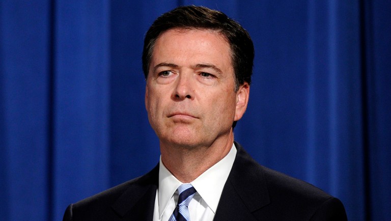 FBI Director James Comey listens during a news conference announcing a deal between the U.S. government and French bank BNP Paribas at the Justice Department in Washington.