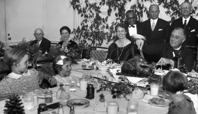 President Franklin D. Roosevelt carves the turkey during the annual Thanksgiving dinner for polio patients at Warm Springs, Ga., with first lady Eleanor Roosevelt smiling beside him, Dec. 1, 1933.