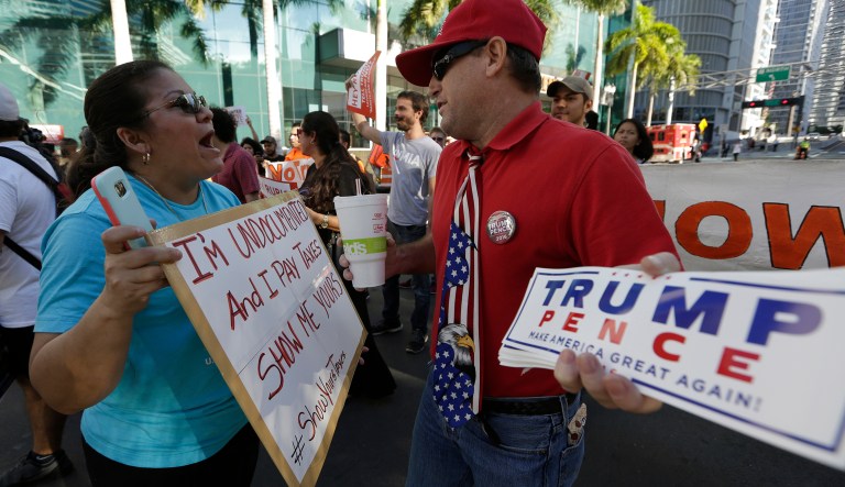 Bertha Sanles, of Miami, left, shouts at Bobby Mayo, of Boca Raton, Fla., a supporter of Republican presidential candidate Donald Trump, as she protests outside of a campaign rally attended by Trump, Friday, Sept. 16, 2016, in Miami. Sanles is an undocumented immigrant who says she pays taxes, and believes Trump should release his tax returns.