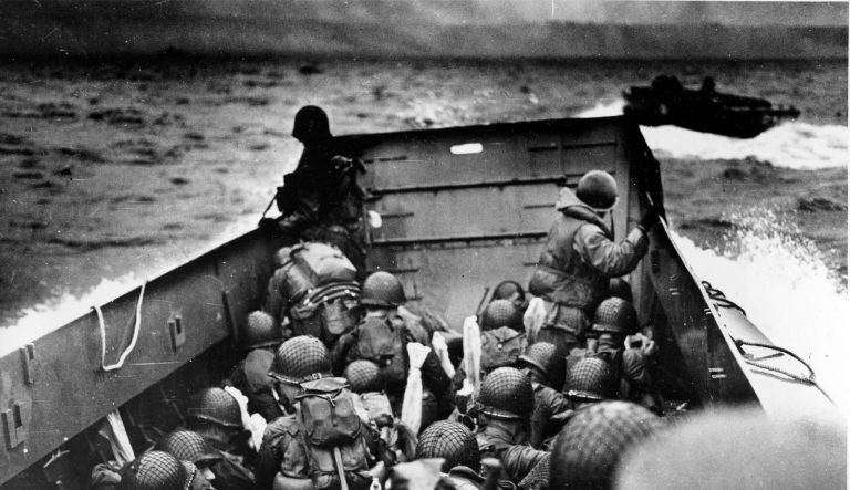 In this photo provided by the U.S. Coast Guard, a U.S. Coast Guard landing barge, tightly packed with helmeted soldiers, approaches the shore at Normandy, France, during initial Allied landing operations, June 6, 1944. These barges ride back and forth across the English Channel, bringing wave after wave of reinforcement troops to the Allied beachheads. 