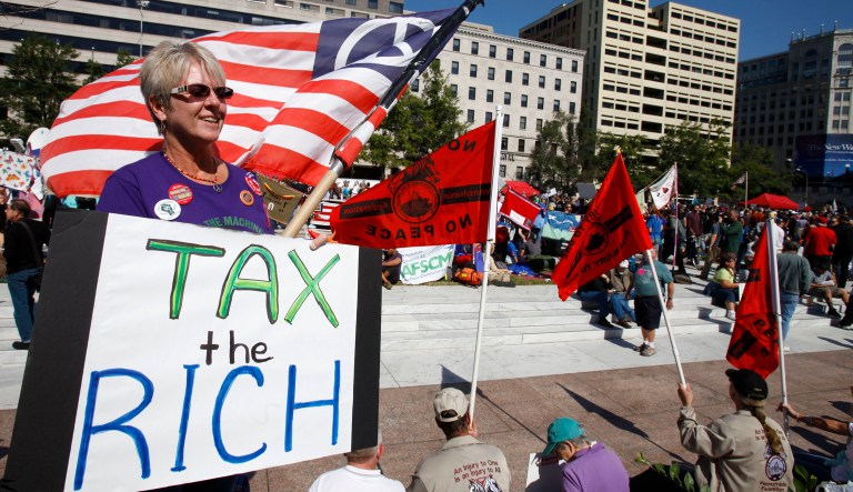 FILE - In this Oct. 6, 2011 file photo, Carol Gay, of Brick, N.J., holds a sign saying "Tax the Rich," as several groups including the Peoples Uprisings, October 2011 Coalition, and Occupy DC, "occupy" Freedom Plaza in Washington. The income gap between the rich and everyone else is large and getting larger, while middle-class incomes stagnate. That's raised concerns that the nation's middle class isn't sharing in economic growth as it has in the past. And it sparked the Wall Street protests that spread to other cities in the country. 