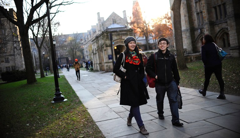 Yale University students walk across the school's campus in New Haven, Conn.