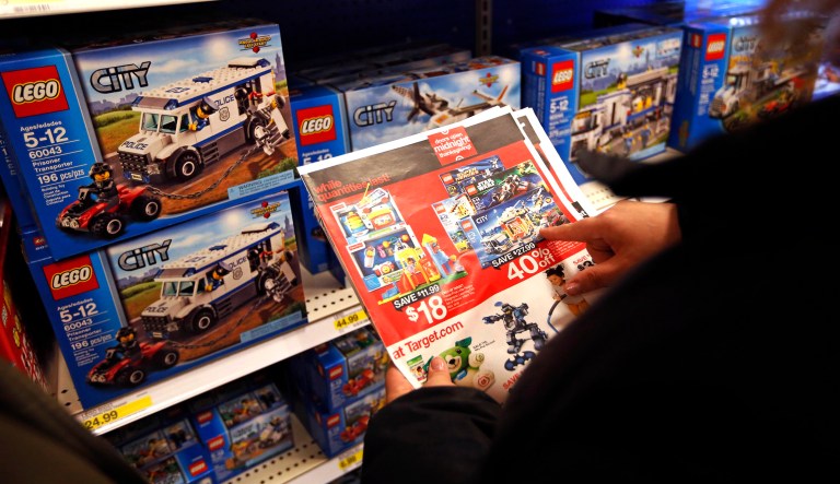 A Target customer uses a flyer to help her find the right Lego toy.