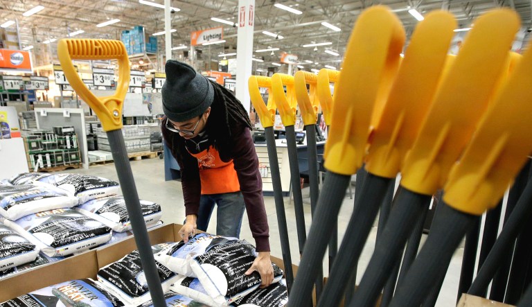 Hardware store department supervisor Romello Williams, of Quincy, Mass., organizes ice-melting pellets at a Home Depot in Quincy.  
