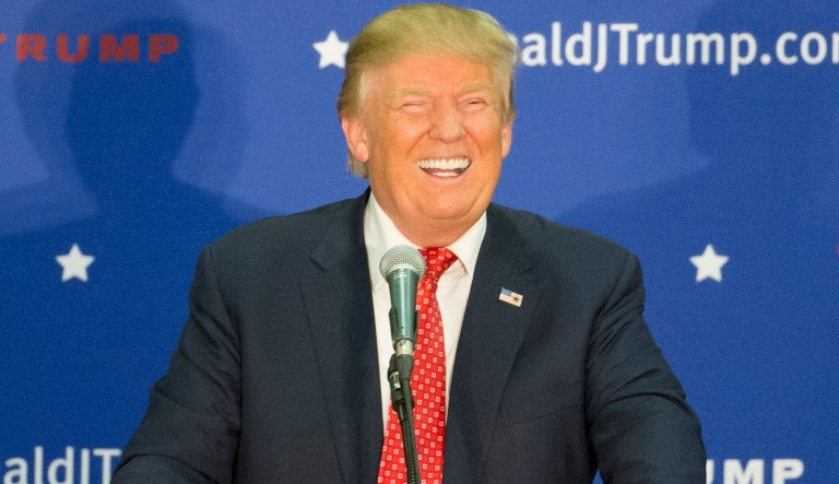 Republican presidential candidate Donald Trump laughs after an attendee makes a joke at Democratic presidential candidate Hillary Clinton's expense during a campaign stop at Concord High School, Monday, Jan. 18, 2016, in Concord, N.H. 