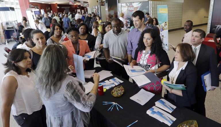 Job seekers get information at a job fair in Sunrise, Fla. The Labor Department releases weekly jobless claims on Thursday. 