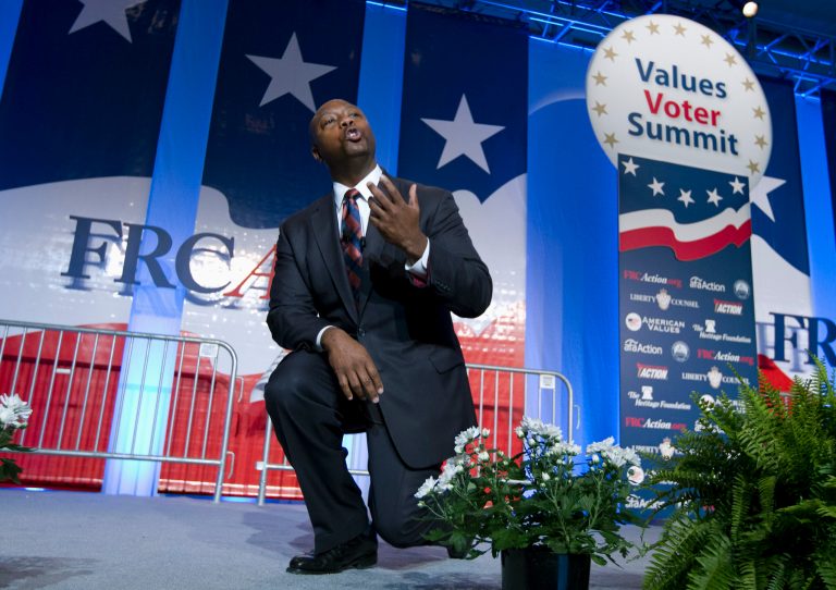 Sen. Tim Scott R-S.C. kneels as he speaks during the Values Voter Summit, held by the Family Research Council Action, Friday, Oct. 11, 2013, in Washington