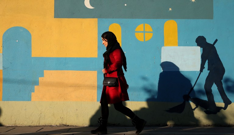 An Iranian woman walks on Enghelab-e-Eslami (Islamic Revolution) St. in Tehran, Iran, Tuesday, Dec. 8, 2015.