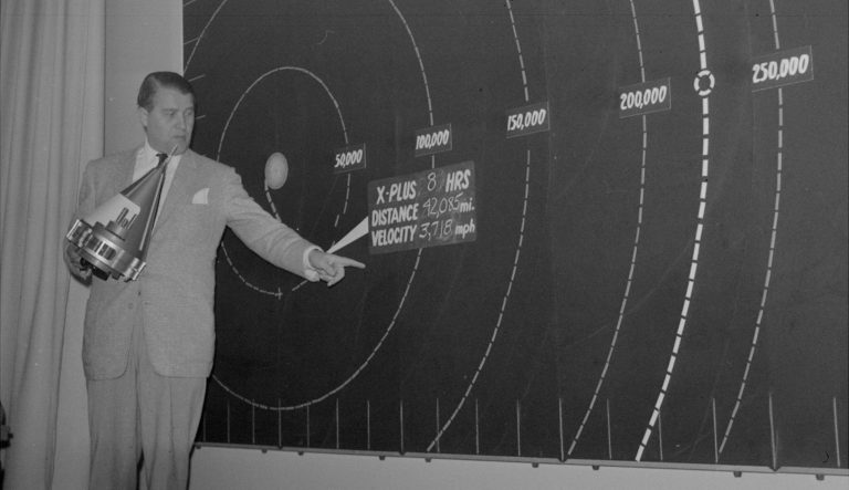 This picture shows Dr. Wernher Von Braun, top army missile expert, indicating on a chart, December 6, 1958, the point in space - 64,830 miles from the earth - the nose cone of Pioneer III is expected to reach before it begins to fall back toward the earth. 