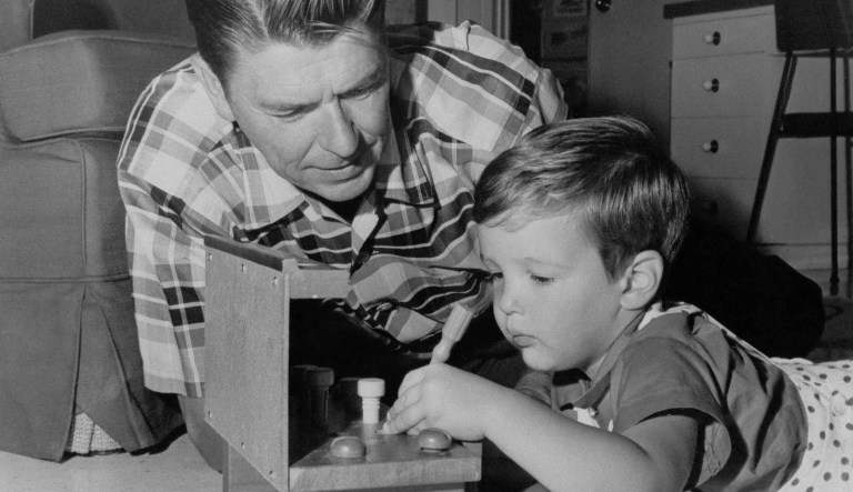 Standard equipment for their hero's home life, in the minds of many movie and T.V. fans, includes a house with swimming pool, a pretty wife, and two children. Ronald Reagan, host of the "General Electric Theatre" on the CBS Television Network. The house is in Pacific Palisades, Calif. The wife is actress Nancy Davis. The children are Patricia Ann, 9, and Ronald Prescott, 2 Reagan gives young Ronald advice as he works with his educational toy on Oct. 19, 1960.