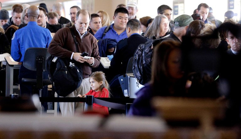 Travelers wait in line to check in at a security checkpoint area at Midway International Airport in Chicago.