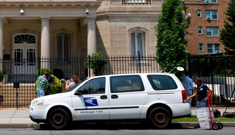 A U.S. Postal Service worker unloads packages in front of the Cuban Interests Section, which serves as the de facto diplomatic mission of Cuba to the United States, Wednesday, July 1, 2015 in Washington.