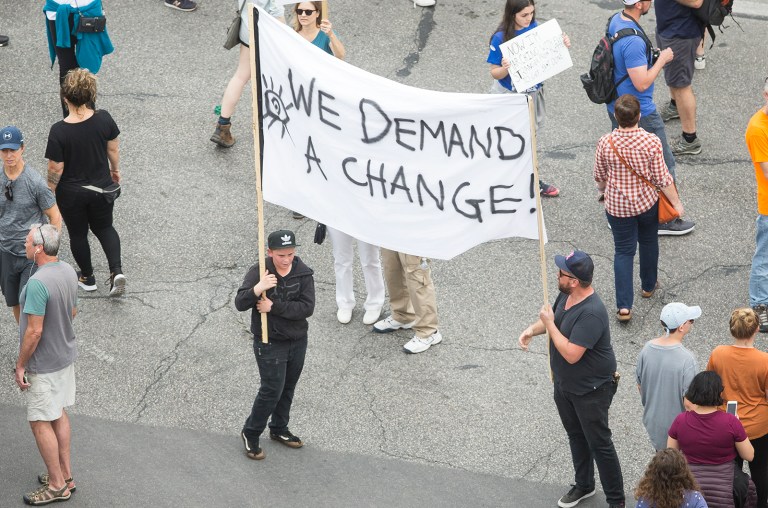 People hold up signs outside of the Texas State Capitol during the March for Our Lives event in Austin, Texas, on Saturday, March 24, 2018. 