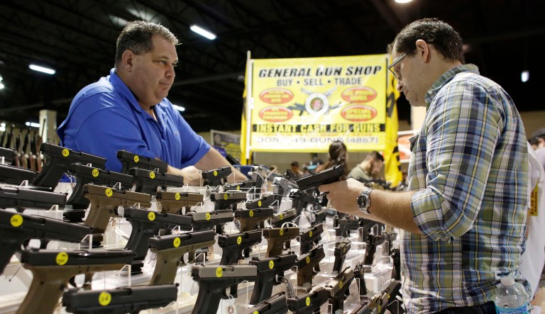 The owner of General Gun Shop shows a customer a Glock 19 at a gun show held by Florida Gun Shows in Miami.