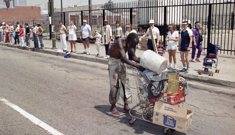 Willie McGee, 79, who lives on the streets of the skid row area of Los Angeles, passes by as people line up along 6th Street for Sundayâs Hands Across America on May 25, 1986. McGee is one of the many homeless that the project is supposed to help.