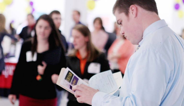 A student looks over possible jobs during a college job fair.