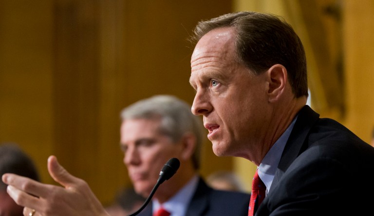 Sen. Pat Toomey, R-Pa., center, joined by Sen. Rob Portman, R-Ohio, left, appear at a hearing.