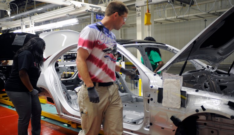 David Reeves, a group leader at the Mercedes-Benz factory in Vance, Ala., wears a red, white and blue T-shirt while inspecting a new sedan during the U.S.-Germany World Cup match on Thursday, June 26, 2014.