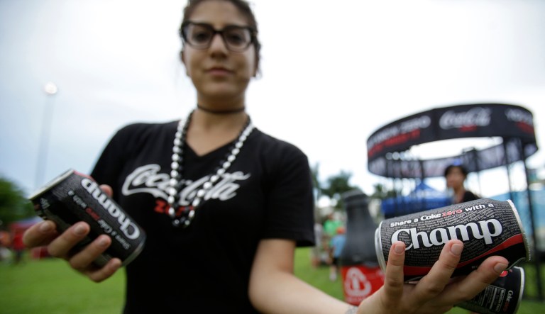 In this Friday, Sept. 11, 2015 photo, Jodie Fistel hands out cans of Coke Zero in Boca Raton, Fla.