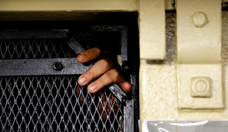 A person reaches out of his cell at San Quentin State Prison in San Quentin, Calif.