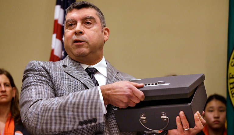 Tony Gomez, Violence and Injury Prevention Manager for Public Health - Seattle & King County, demonstrates the use of a gun lock box during a news conference by the Alliance for Gun Responsibility and other activists, Thursday, Jan. 21, 2016, in Olympia, Wash. Lawmakers in Washington state were to begin discussions later in the day on a list of gun-control measures that include requiring safe storage of firearms to avoid tragedies like the Marysville high school shooting and prohibiting law enforcement agencies from selling confiscated guns.