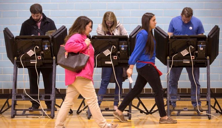 A poll worker leads a voter to an electronic voting machine at the Schiller Recreation Center polling station in Columbus, Ohio.
