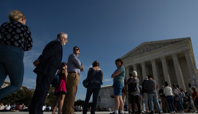 People line up in front of the U.S. Supreme Court, Monday, Oct. 7, 2019, in Washington.