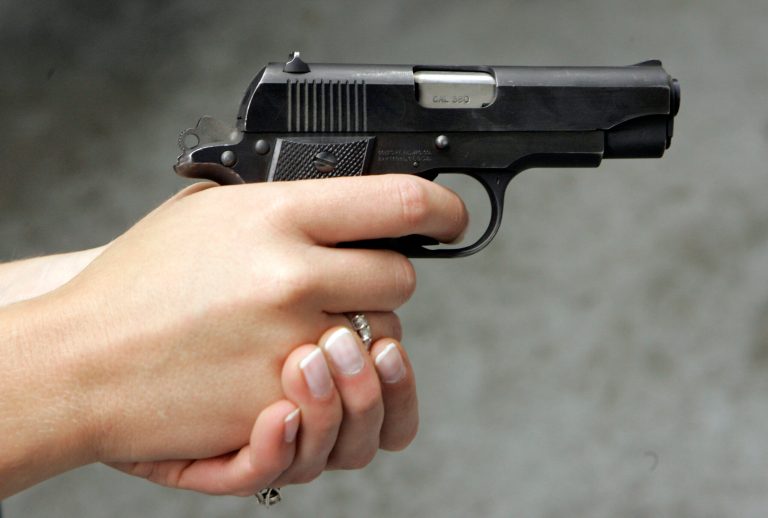Jennifer Deasy holds her Colt Government .380 caliber pistol at the target range at Niagara Gun Range.