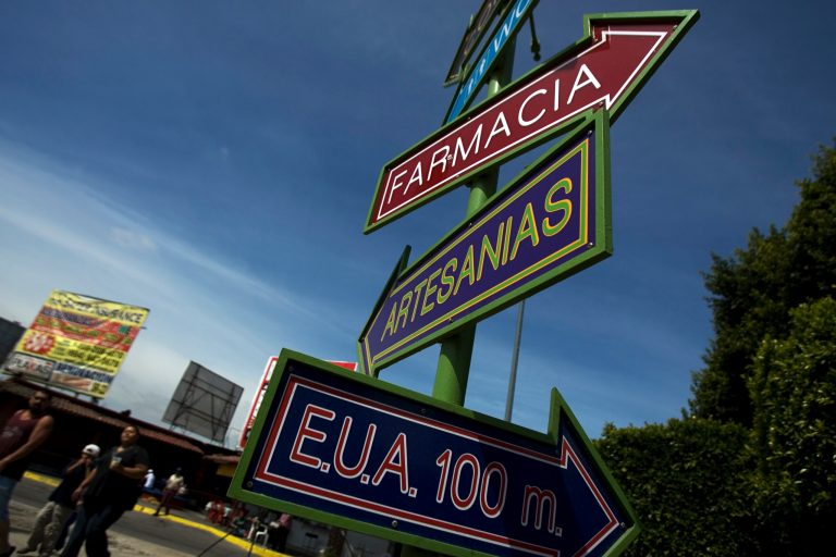 Signs, reading in Spanish "Drugstore, handicrafts and U.S. 100 meters," are seen at the international border crossing between San Ysidro, CA, and Tijuana, in Mexico. 