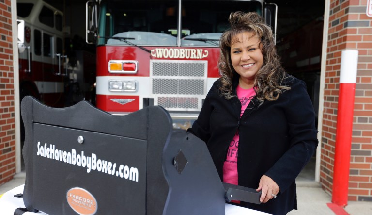 In this file photo taken on Feb. 26, 2015, Monica Kelsey, firefighter and medic who is president of Safe Haven Baby Boxes Inc., poses with a prototype of a baby box, where parents could surrender their newborns anonymously, outside her fire station in Woodburn, Indiana.